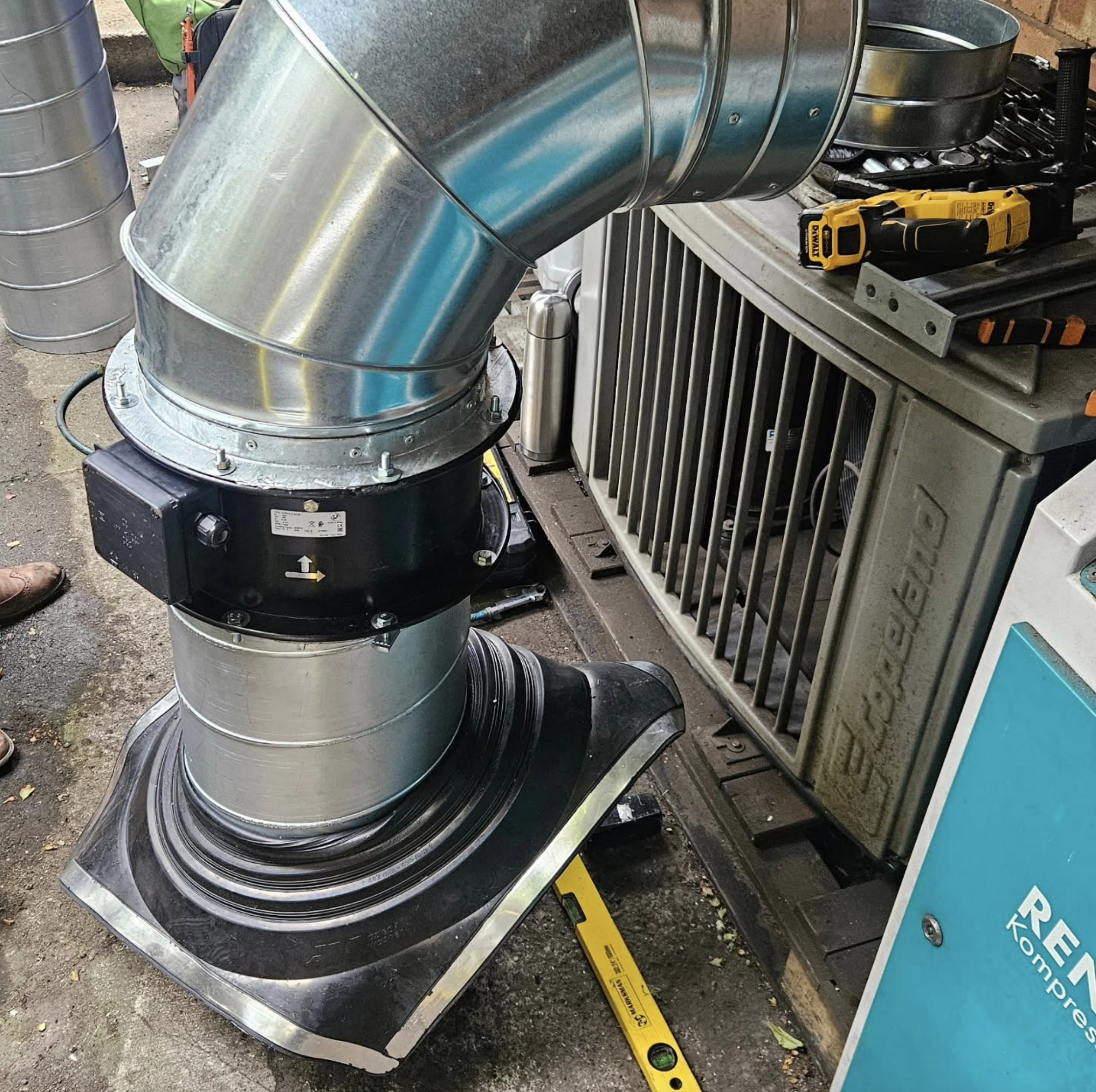 External fan and galvanised duct installation beside commercial equipment